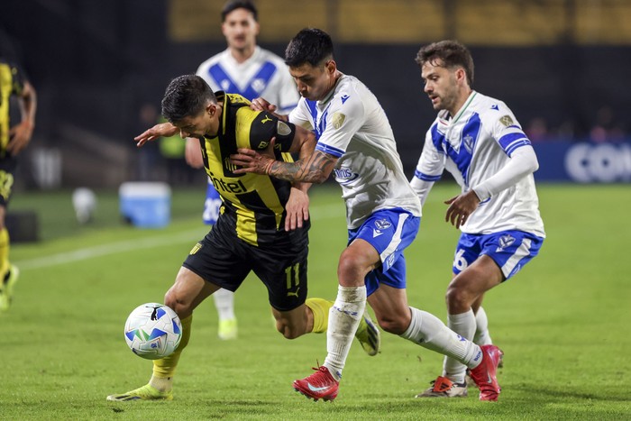 Maximiliano Silvera, de Peñarol, y Agustín Bouzat y Claudio Baeza, de Vélez Sarsfield, el 29 de mayo, en el Campeón del Siglo. · Foto: Rodrigo Viera Amaral